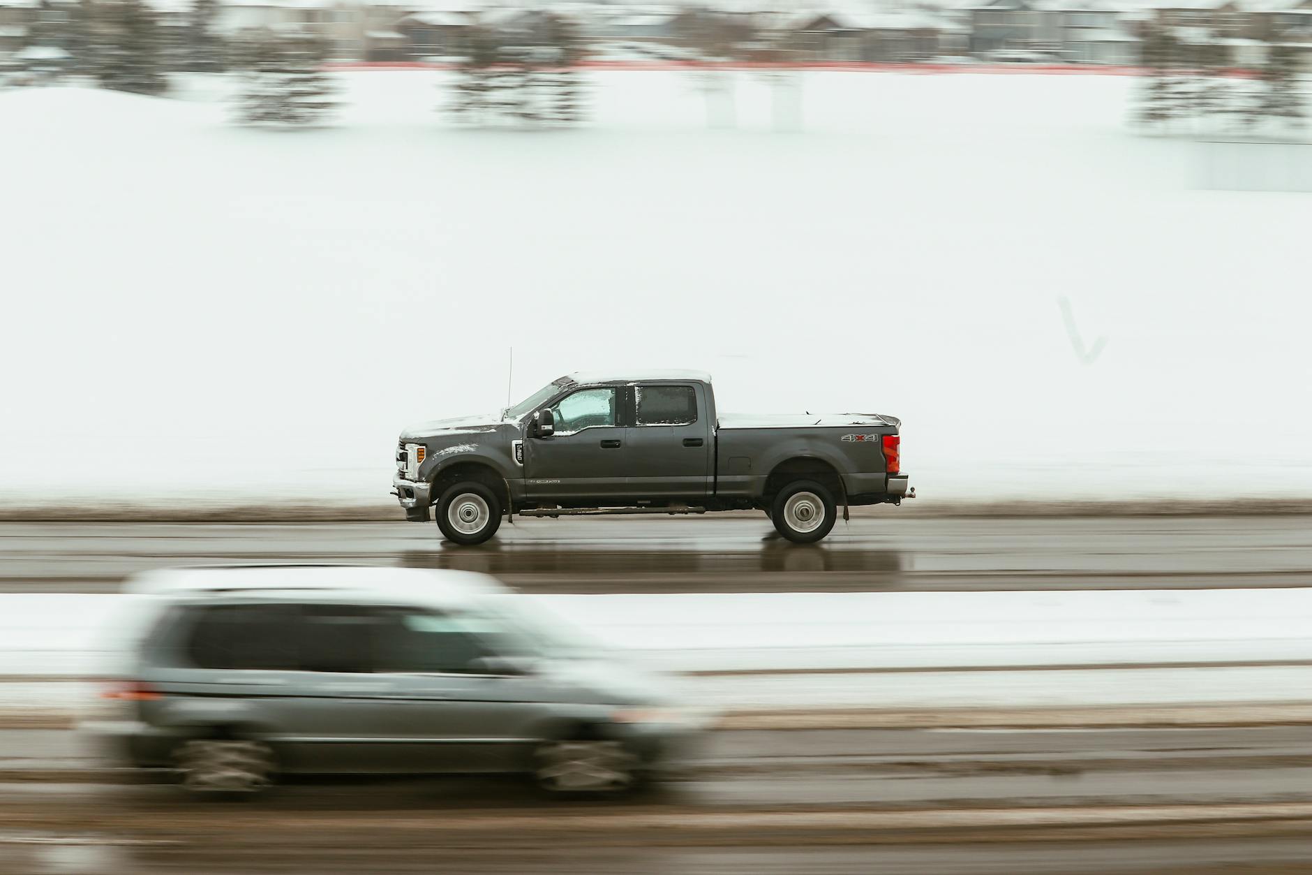 A truck parked on a road with a shield icon labeled “trucks and pickups insurance” over it.