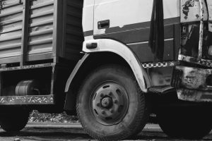 Commercial vehicle driving on road with insurance document overlay for affordable coverage in Kenya.